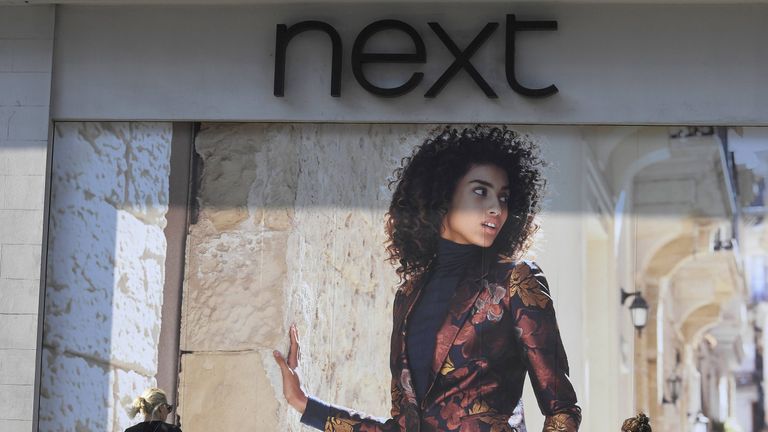 Shoppers walk past a branch of the Next retail store in London, England in November 2016