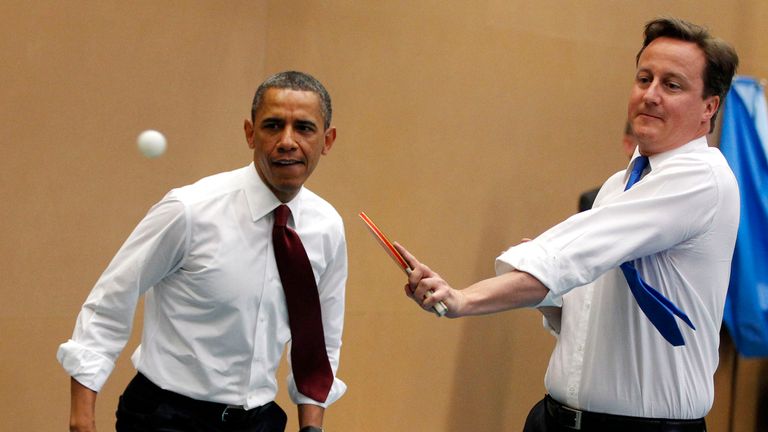 Barack Obama plays table tennis against students with David Cameron at the Globe Academy in London, 2011