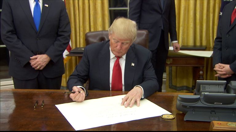 President Donald Trump signs an executive orders calling for the repeal of Obamacare