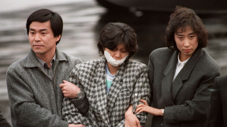 North Korean agent Kim Hyon-Hee is flanked by South Korean investigators as she arrives in Seoul in December 1987 