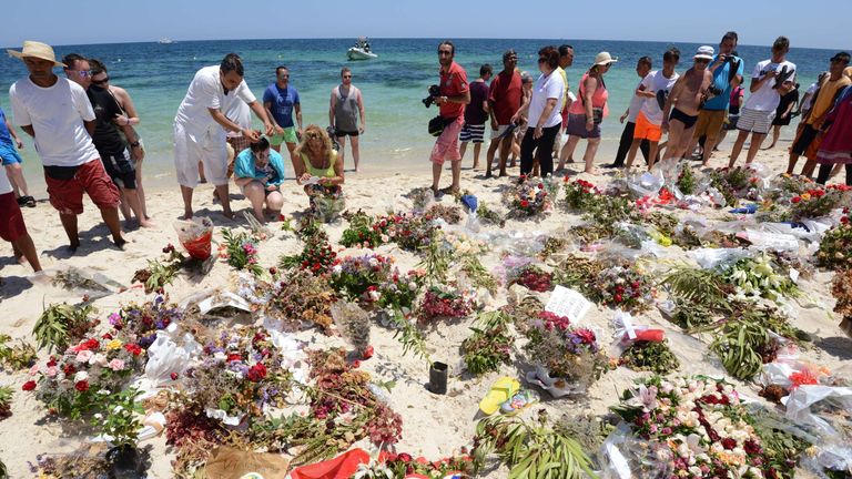 Tourists and Tunisians take part in a ceremony on July 3, 2015, in memory of those killed the previous week by a jihadist gunman in front of the Riu Imperial Marhaba Hotel in Port el Kantaoui, on the outskirts of Sousse south of the capital Tunis. Tunisia has arrested eight people in connection with last week&#39;s jihadist massacre at the seaside resort, as the remains of more slain Britons were flown home on July 2