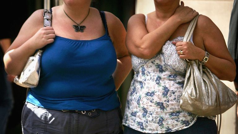 Two women wait to cross a road on August 25, 2006 in London, England. The Department of Health have released a report that predicts the number of obese adults and children in England to rise to 13m by the year 2010