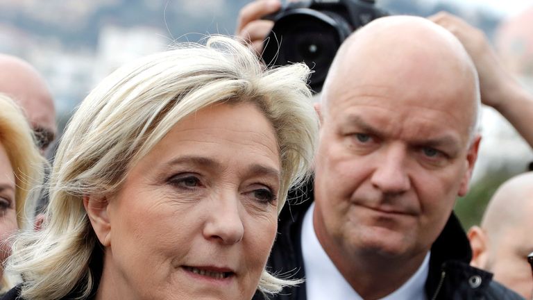 Marine Le Pen and, behind her, bodyguard Thierry Legier