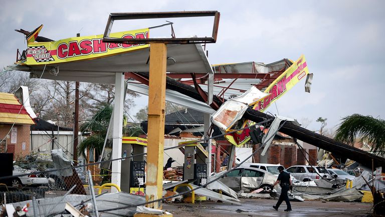A police officer walks through a damaged gas station along Chef Menture Avenue after a tornado touched down in the eastern part of the city on February 7, 2017 in New Orleans, Louisiana