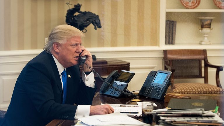 President Donald Trump speaks on the phone with Australian Prime Minister Malcolm Turnbull in the Oval Office of the White House, January 28, 2017 in Washington, DC. On Saturday, President Trump is making several phone calls with world leaders from Japan, Germany, Russia, France and Australia