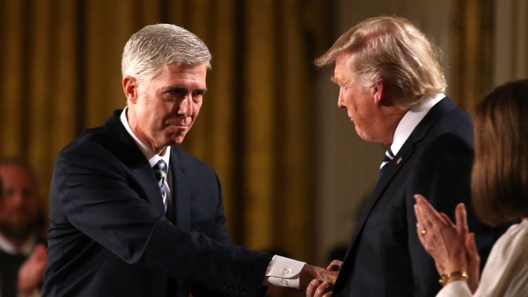 Judge Neil Gorsuch (L) shakes hands with U.S. President Donald Trump as Gorsuch&#39;s wife Louise (R) applauds after President Trump nominated Gorsuch to be an associate justice of the U.S. Supreme Court at the White House in Washington