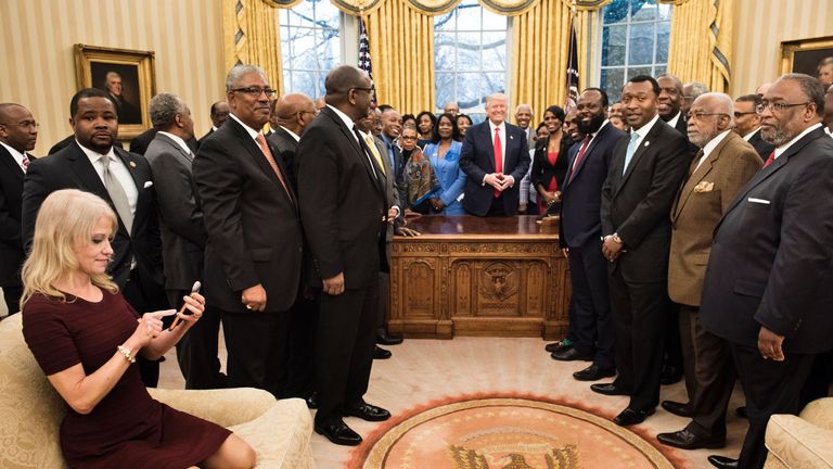 Kellyanne Conway checks her phone after taking a photo as US President Donald Trump