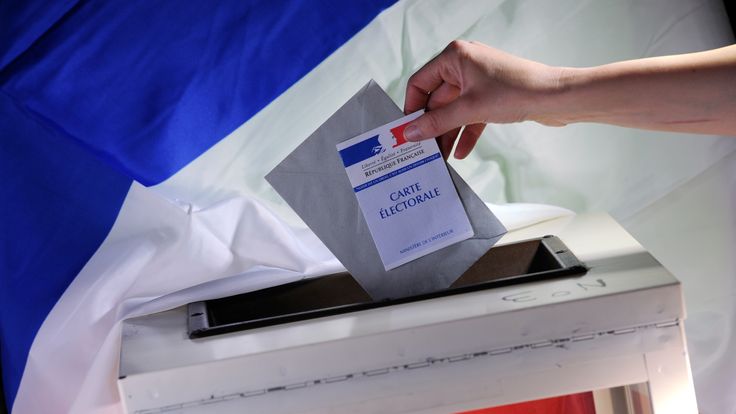 A voter prepares to cast their vote in the French elections