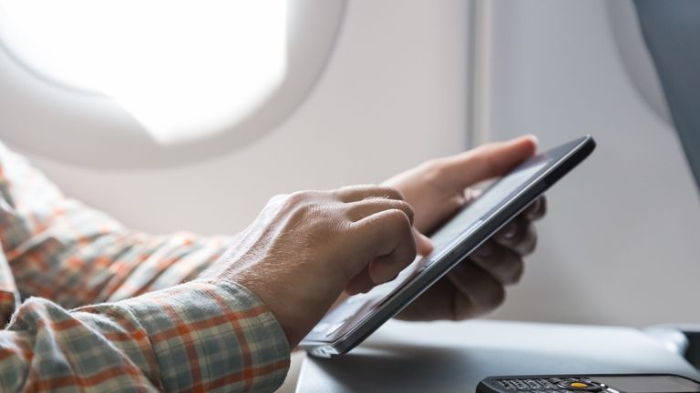 A man uses a tablet device on an airplane. File picture