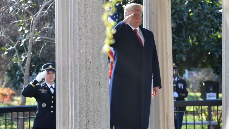US President Donald Trump salutes after laying a wreath at the tomb of former president Andrew Jackson