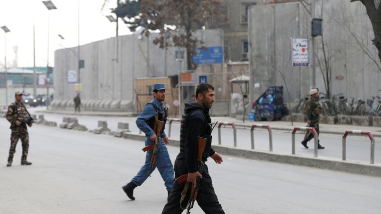 Afghan policemen arrive at the scene after a military hospital in Kabul comes under attack