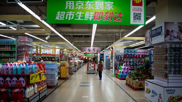 A woman stands in an almost empty Lotte Mart in Shanghai