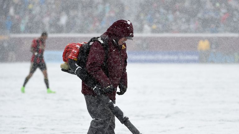 A crew member melts the snow on the lines at a match between the Minnesota United FC and the Atlanta United FC