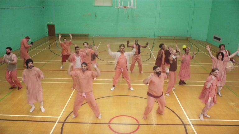 The band members and celebrities dance together in the gym