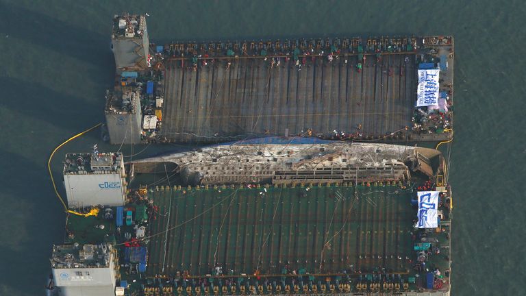 The Sewol ferry was lifted between two barges during the salvage operation