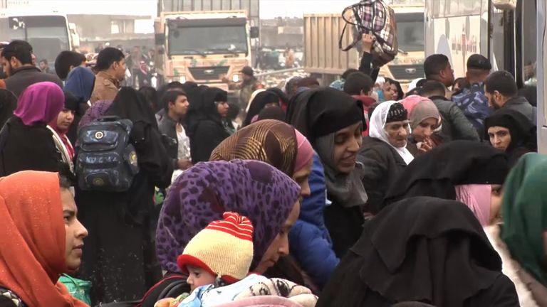 Desperate residents queue to get on buses to a refugee centre