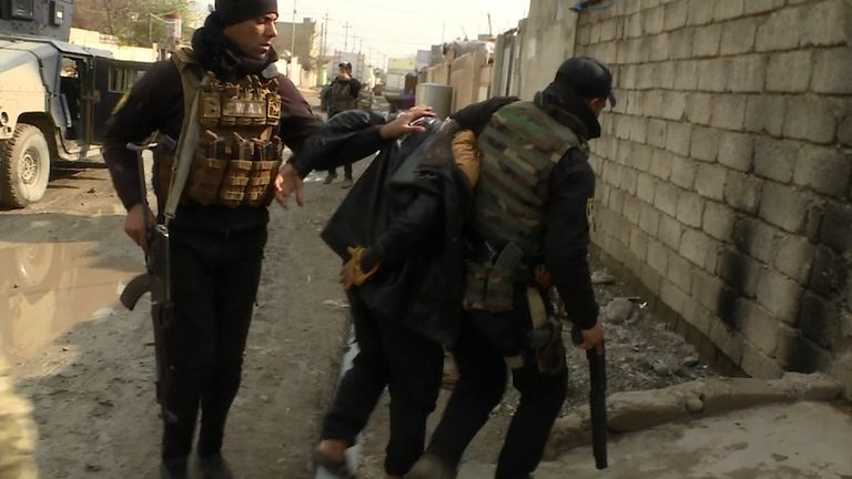 An Iraqi SWAT team grabs a suspected IS militant in east Mosul
