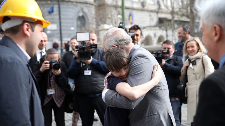 Prince Charles embraces Valentin Blacker during his visit to Bucharest