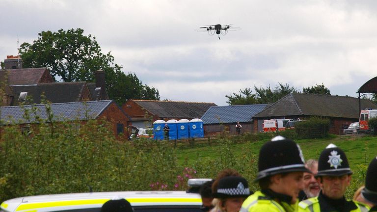 A police drone flies over a line of officers blocking protesters in Derbyshire