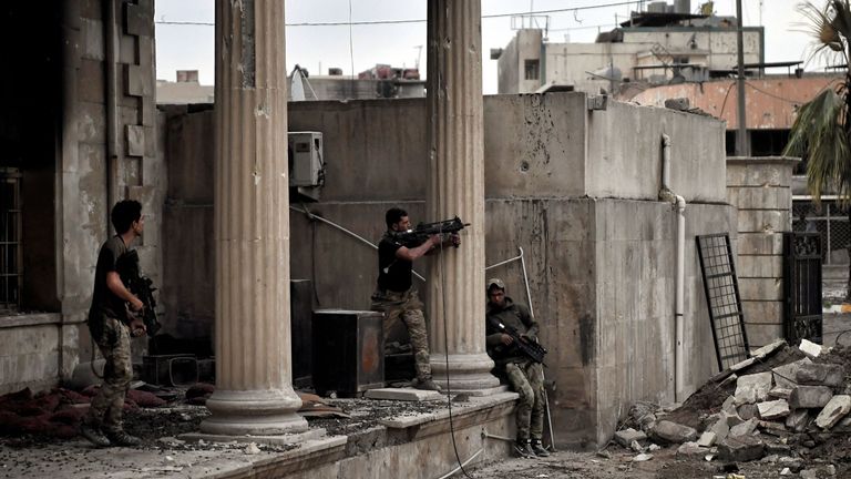 Iraqi forces members fire towards Islamic State (IS) jihadists' positions in west Mosul on March 11, 2017 during the ongoing battle to retake the city from the group