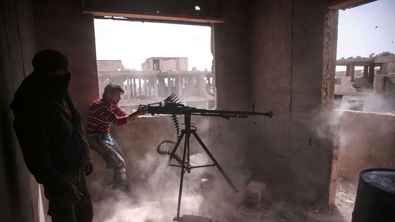 An opposition fighter fires a heavy machine gun in Jobar