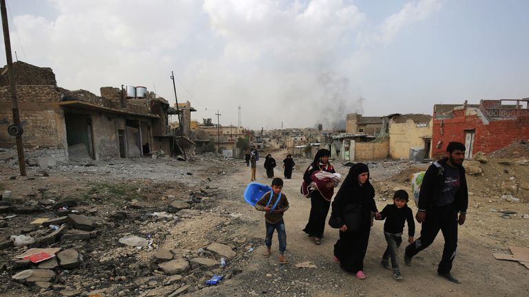 Iraqi families leave Mosul&#39;s Nablus neighbourhood on March 12, 2017, during an offensive by security forces to retake the western parts of the city from Islamic State (IS) group fighters