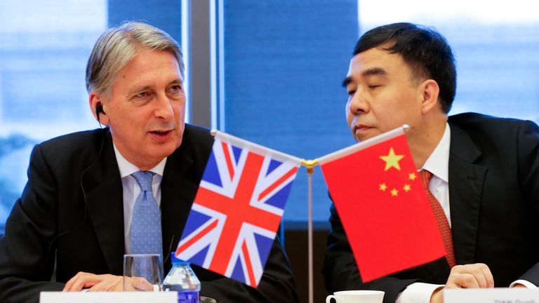 Close crop of flags as Chancellor Philip Hammond (L) and Bank of China chairman Tian Guoli (R) attend the UK-China High Level Financial Services Roundtable at the Bank of China head office building in Beijing on July 22, 2016. 