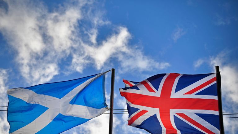 A saltire flag and Union Jack flutter in the wind 