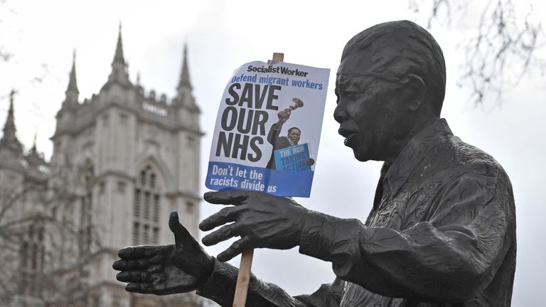 A poster hanging from the Statue of Nelson Mandela at a rally in central London, in support of the NHS