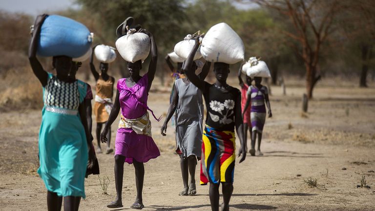 Women carry food in gunny bags from an aid centre in Ngop, South Sudan