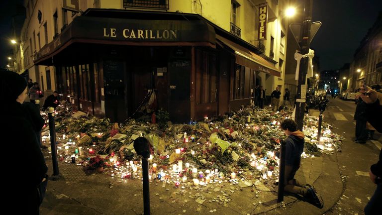 People pray outside Le Carillon restaurant, one of the attack sites in Paris