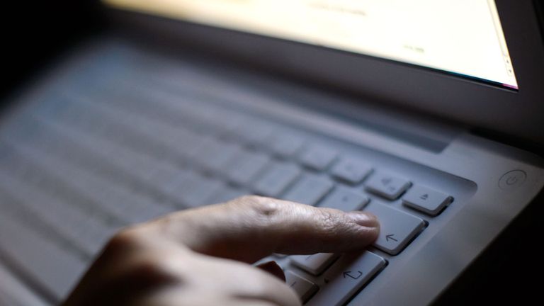 A person presses the backspace key on an Apple keyboard