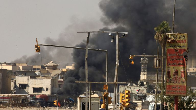 Thick black smoke pours from an area in western Mosul as Iraqi forces battle with IS