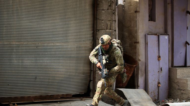  A member of the Iraqi forces, consisting of the Iraqi federal police and the elite Rapid Response Division, runs for cover
