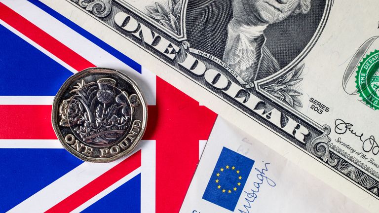 The new £1 pound coin is seen alongside US dollar bills and euro notes on April 4, 2017 in Bath, England