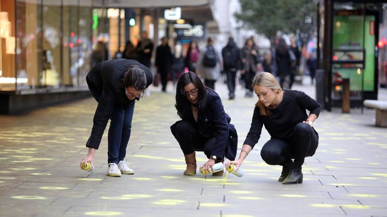 Ruth Pipkin, Lina Solanki and Natalie Merrix - representatives from The Chewing Gum Action Group (CGAG), highlight pieces of discarded gum, using fluorescent chalk, on the pavements of Oxford Street, London