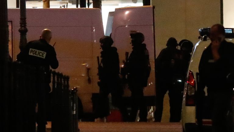 Police secure a side street as others conduct an investigation on the Champs Elysees Avenue