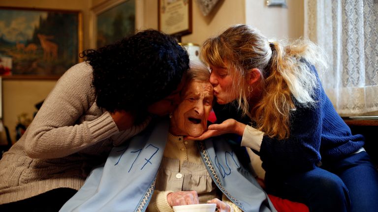 Emma Morano is kissed by her caretakers Malgorzat Ceglinska and Yamilec Vergara during the 117th birthday