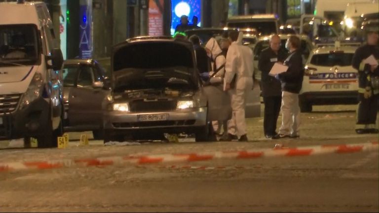 Forensics officers search a car on the Champs-Elysees