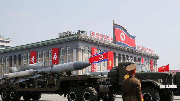 Missiles are driven past North Korean leader Kim Jong Un and other high ranking officials