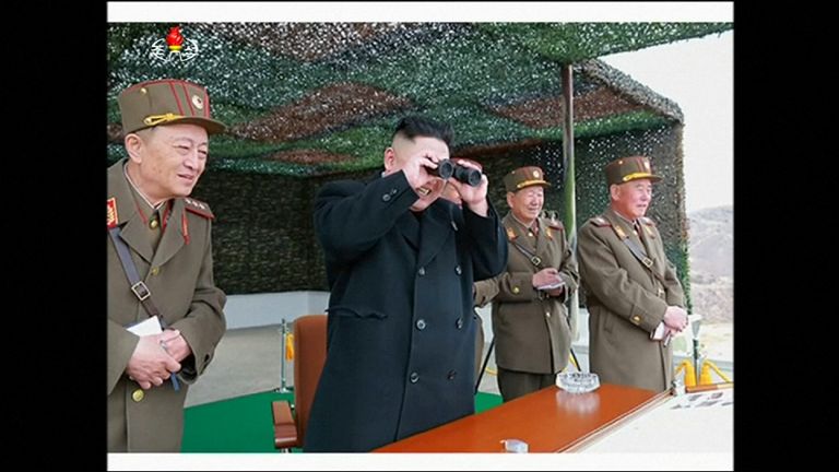 Kim Jong-Un smiles as he watches the action