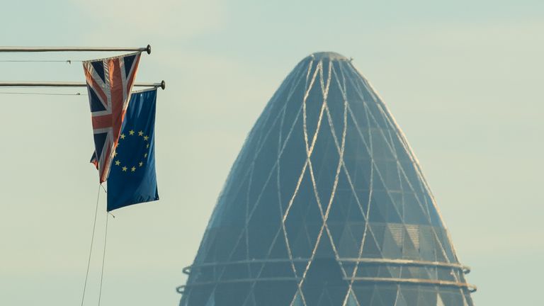 A Union Flag and a European Union flag seen alongside 30 St Mary Axe, also known as the Gherkin, in the City financial district of central London
