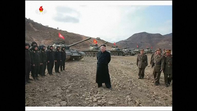 Kim Jong-Un stands in front of the tanks taking part in the competition