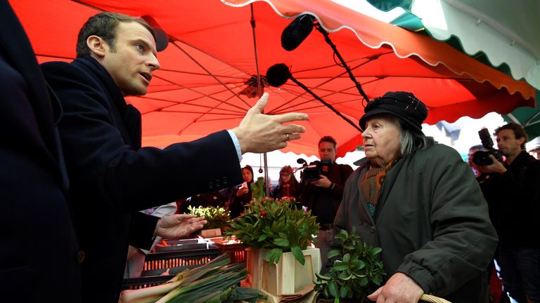Emmanuel Macron speaks with a stallholder in a market in Poitiers, central France