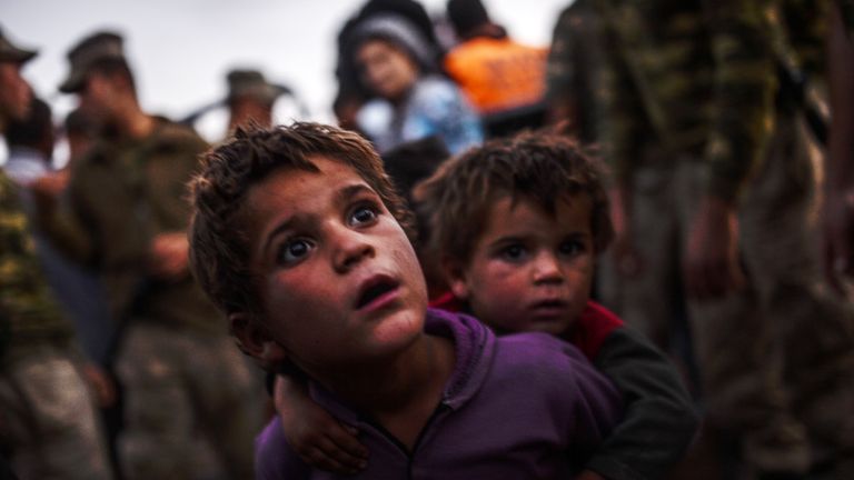 Syrian Kurdish children arrive at the border between Syria and Turkey after several mortars hit both side in the southeastern town of Suruc, in the Sanliurfa province on September 29, 2014