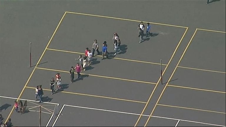 Children are escorted across the playground after the shooting