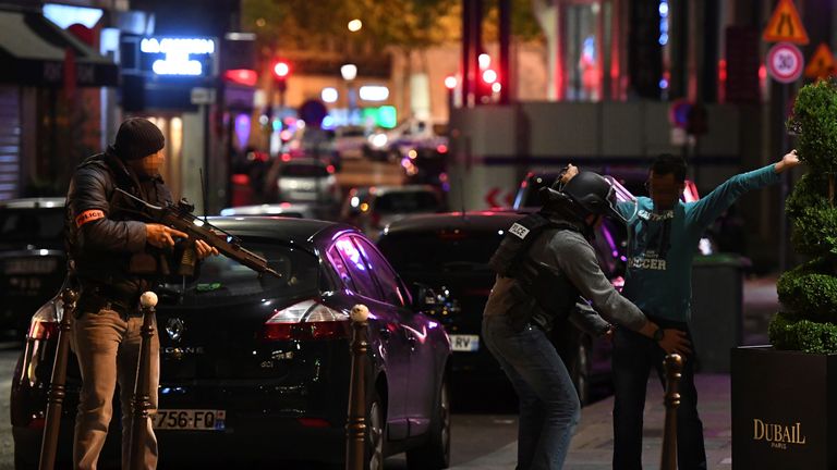 Police officers searching a man on the Champs-Elysees