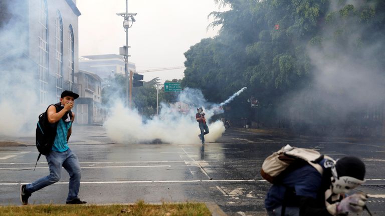 
Demonstrators clash with riot police while rallying against Venezuela's President Nicolas Maduro in Caracas, Venezuela