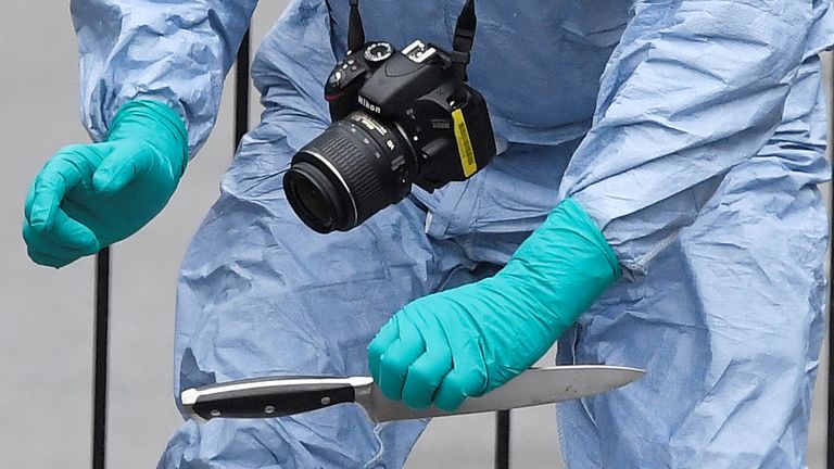 A forensic investigator recovers a knife after man was arrested on Whitehall in Westminster, central London