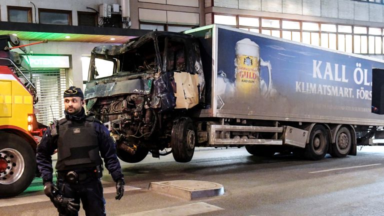 A truck tows away the hijacked lorry which struck pedestrians and crashed into a department store